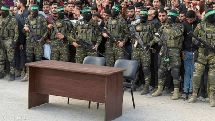 قبل تسليم الرهائن.. طاولة وكرسيين "فارغيين" تثير التساؤلات